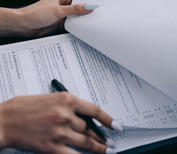 Detailed view of a person holding documents and a pen, ideal for business content.